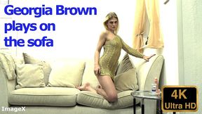 georgia brown plays on the sofa