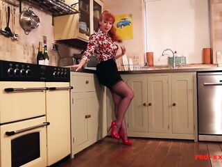 Smokin' sexy redhead aged RedXXX bangs her sextoy in the kitchen