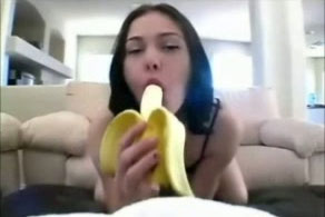 Beautiful and playful brunette girl is eating banana like a dick