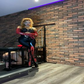 A sexy, natural redheaded ginger is performing CBT and dominating in bed while wearing red boots