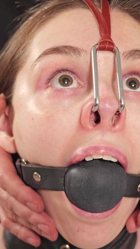 Stacy - Topless Slave in Tight Leather Restraints with Large Ballgag and Nose Hook