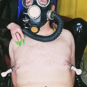 Slave in a gas mask. Fetish. Pumping male nipples, playing with nipples.