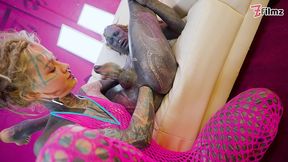 tattooed dominatrix in pink fishnet