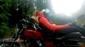 Red lips blonde smoking sensually on Rasta bike outdoor