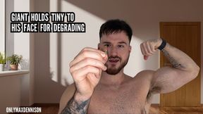 Giant holds tiny upto his face her degrading