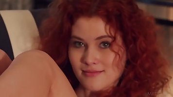 Red haired darling with long legs, Adel C is posing naked in front of the camera