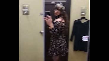 Travesti jugando en los vestidura de tienda prob&aacute_ndose vestidos