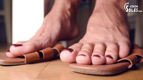 Worn sandals, bare feet and shoe dangling POV