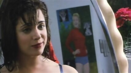 Alanna Ubach of Girlfriends' Guide to Divorce fame standing in front of a mirror as she removes her blue robe to reveal a blue bra and her ass in blue thong panties