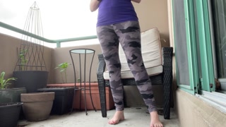 girl wetting grey leggings outside on the balcony