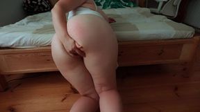 Busty MILF in nightgown masturbates by the bed.