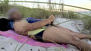 Jerking Off on a Public Beach in Black Gold Racing One Piece