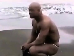 Asian bodybuilder barely covered at the beach