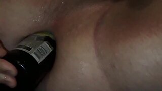 Crossdresser tries to fuck herself with a beer bottle