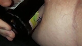 Crossdresser tries to fuck herself with a beer bottle