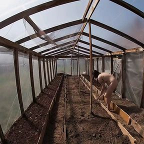 Nude house wife working in the greenhouse