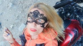 Red lips blonde smoking sensually on Rasta bike outdoor