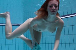 Busty redhead European babe spreads her legs under water