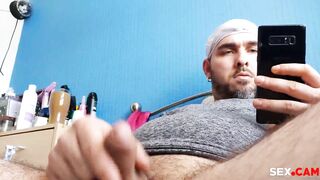 He masturbates while looking at his cell phone