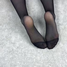 Mistress caresses her feet in black nylon pantyhose