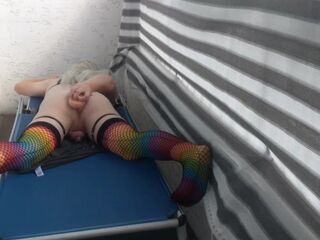 Caged sissy plays with her dildo on public balcony