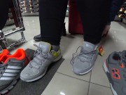 Foot fetish in a public shoe store. Fat legs try on sneakers.