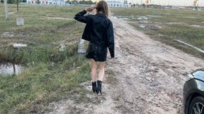 A girl in ankle-high boots in high heels walks through a ditch with mud and stinking water that fills her boots from the inside (re-realize)