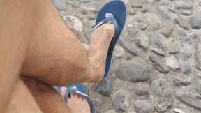 Dangling flip flops on a public bench