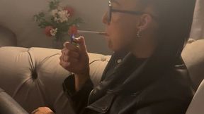 Smoking in full leather outfit on sofa