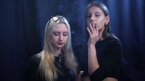 Two Women Smoking Together in a Dark Studio with Soft Blue Lighting