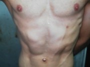 hombre joven jugando con sus pechos, y abdomen marcado