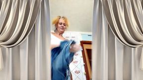 Mature housewife Lukerya flirts online, shows off her naked breasts, and changes clothes in the kitchen.