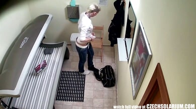 Blonde with piercings and tattoo caught adjusting jeans in solarium mirror