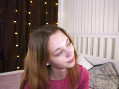 Cute Brunette Girl Posing and Smiling in Cozy Bedroom