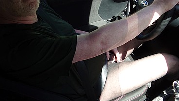 Nylonjunge fährt Auto in schwarzer Feinstrumpfhose