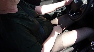Nylonjunge fährt Auto in schwarzer Feinstrumpfhose
