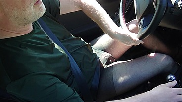Nylonjunge fährt Auto in schwarzer Feinstrumpfhose