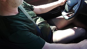 Nylonjunge fährt Auto in schwarzer Feinstrumpfhose