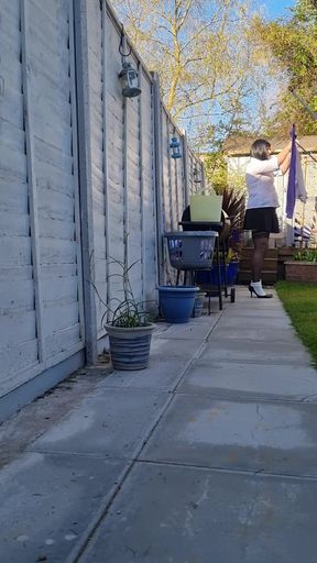 Sexy girl hanging the washing out.