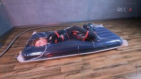 Bondage with red ropes of a special agent in a vacuum bag on an air mattress