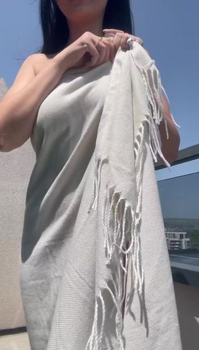 Blonde woman in a white dress holding a fringed shawl