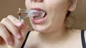 A giantess stepmom traps her tiny ex-husband in a trap made of chewing gum; she chews, blows bubbles, and ensnares him.