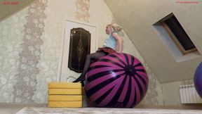 Alla happily jumps high on two large inflatable balls and pumps them with her mouth.