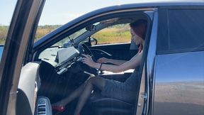 A girl in a car is stuck in a field, the car won't start and the girl doesn't know what to do