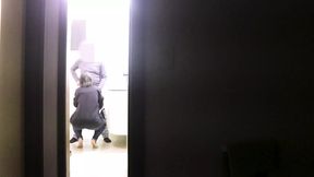 She gives a blowjob to her friend while her husband watches a series on TV.