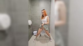 Pale redhead and her sex friend pee in public toilets