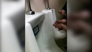 two slim dicks getting wanked at the urinals