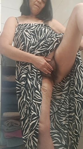 in the bathroom showing what's under her dress to her young lover on camera