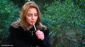 Absolutely Stunning Lady Is Smoking Two Long Cigarettes In The Park