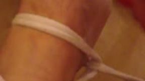 Miss M tickles a mans feet with brush whilst he is tied to bed